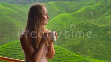 年轻女子坐在咖啡馆里观看高地茶种植和喝茶。